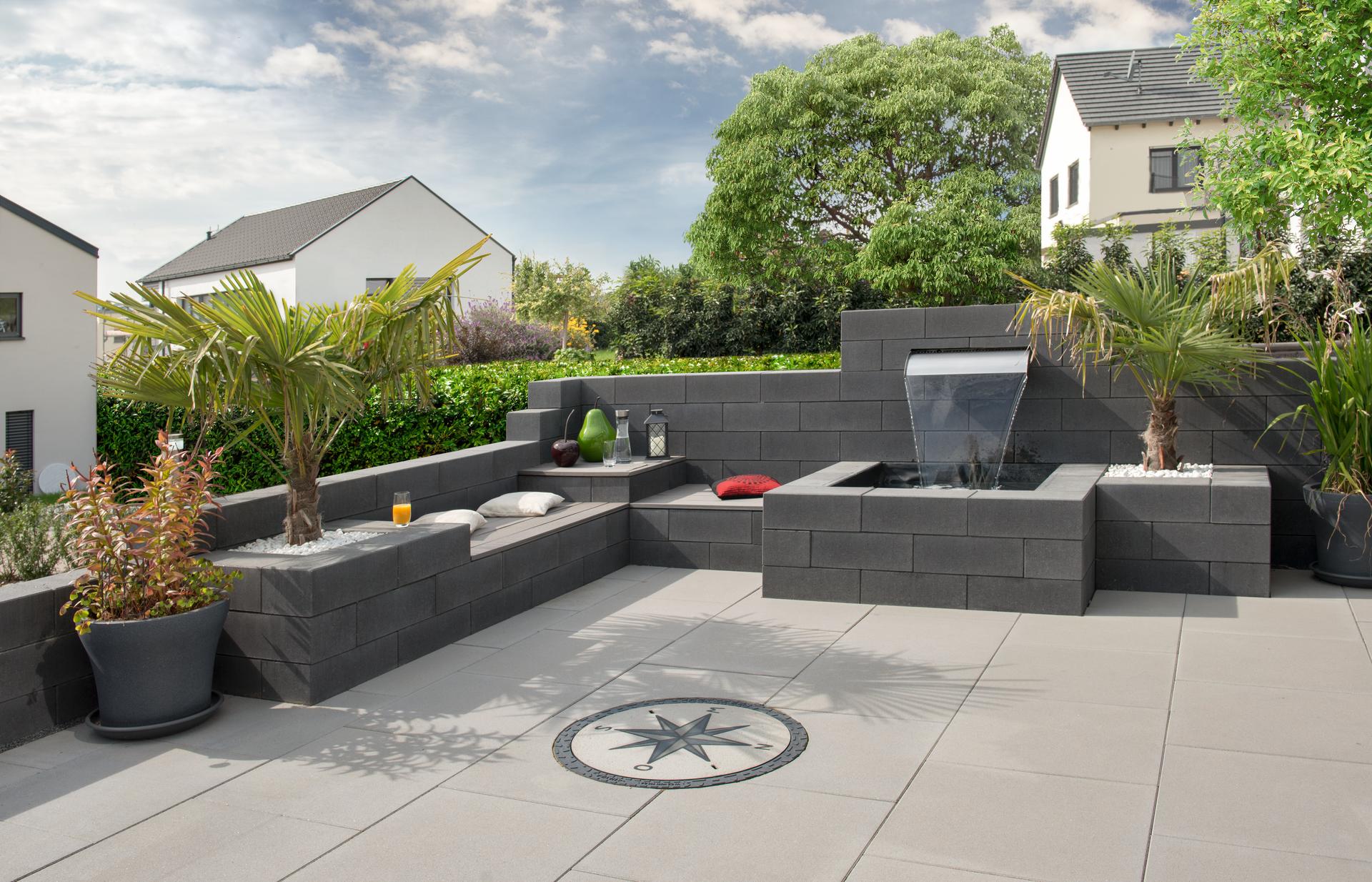 Terrasse mit DIY-Sitzecke und Brunnen aus einer Gartenmauer