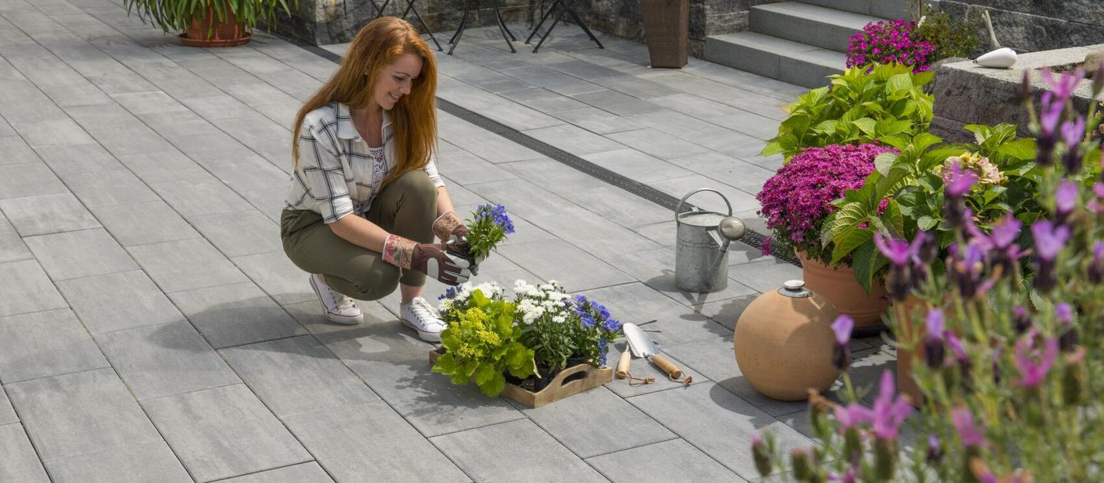 Une femme dépose des fleurs dans un pot