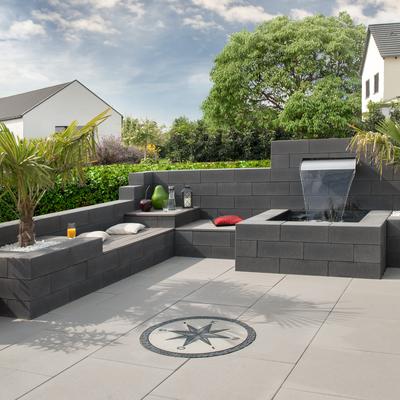 Terrasse mit DIY-Sitzecke und Brunnen aus einer Gartenmauer