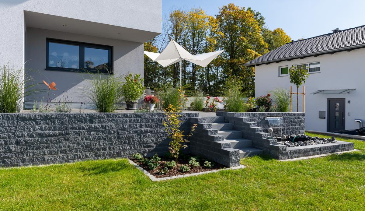 [Translate to Französich:] Terrasse mit Gartenmauer in anthrazit