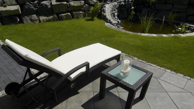 Terrasse mit Liegestuhl und Gartenteich