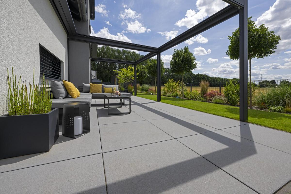Terrasse mit grauen Terrassenplatten und Gartenlounge