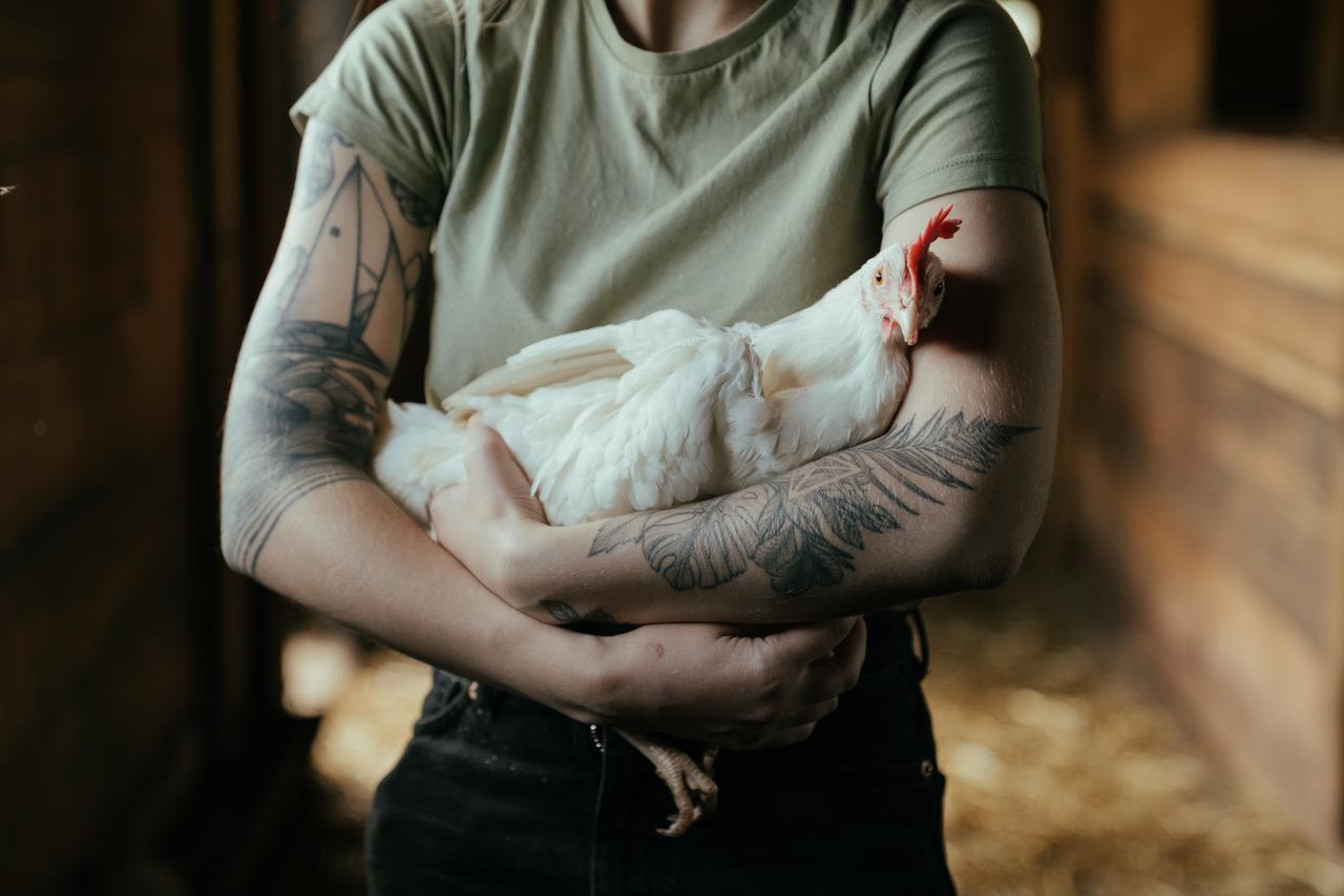 Frau hält Huhn im Arm